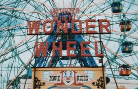 Coney Island Ferris Wheel against blue sky.