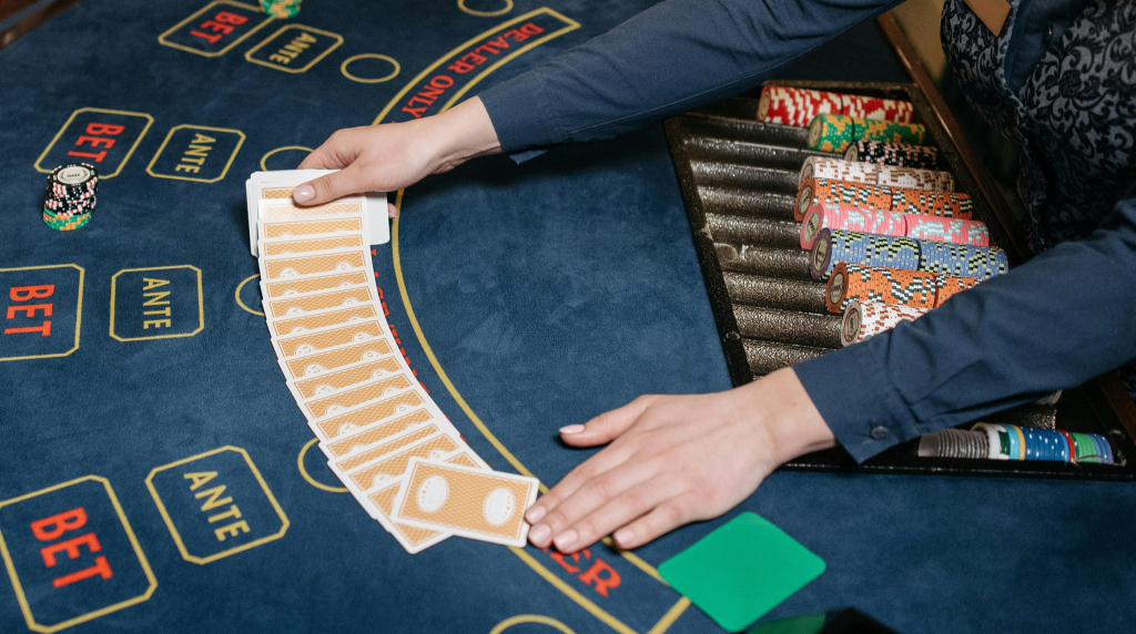 A blackjack table with a dealer spreading a deck of cards