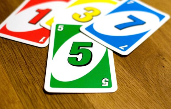 Uno Cards strewn across a wooden table