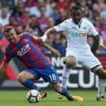 Crystal Palace and Swansea players compete in a Premier League Match
