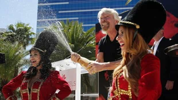 Branson celebrates with champagne at the announcement of the acquisition in Las Vegas.