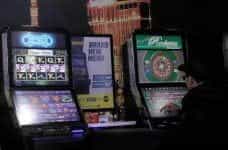 A man playing at a fixed odds betting terminal in a shop.