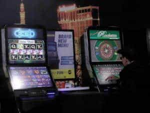 A man playing at a fixed odds betting terminal in a shop.