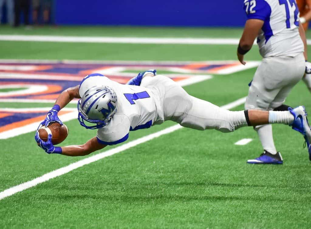 American footballer leaping for the goal line.