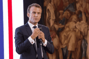 French President Emmanuel Macron speaks into a microphone.