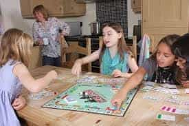 A picture of three young girls playing Monopoly.