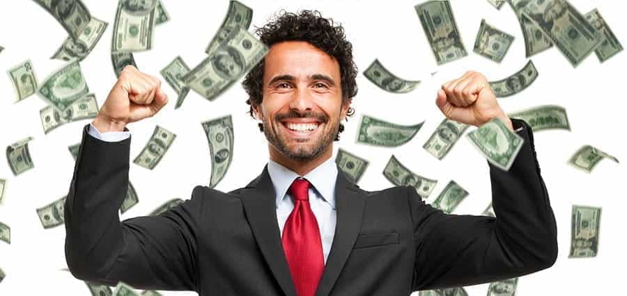 A man in a suit smiling as it rains cash.