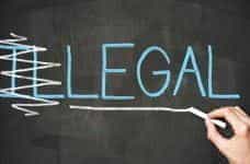 The word "illegal" written on a chalkboard, with the first two letters scored out, so that it reads "legal".