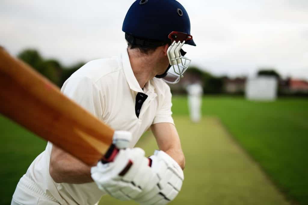 Cricket player facing the field, holding bat ready to hit the ball.