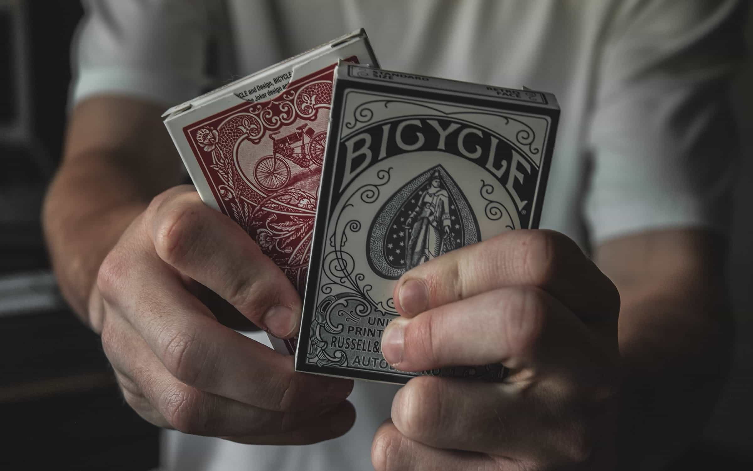 Two packs of playing cards being held up.