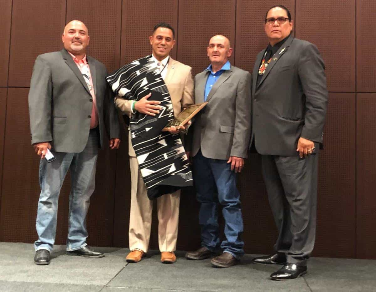 Rodney Butler receiving award from three other officials.