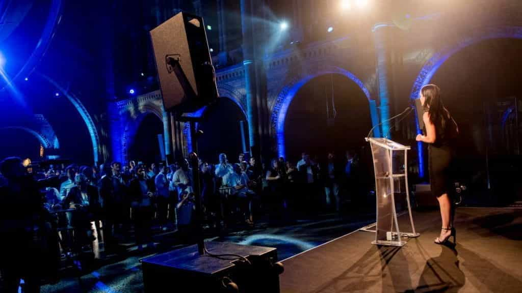 Woman on stage announcing the Pride of Gaming Awards.