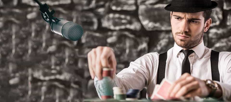 A man playing poker, with a microphone next to him.