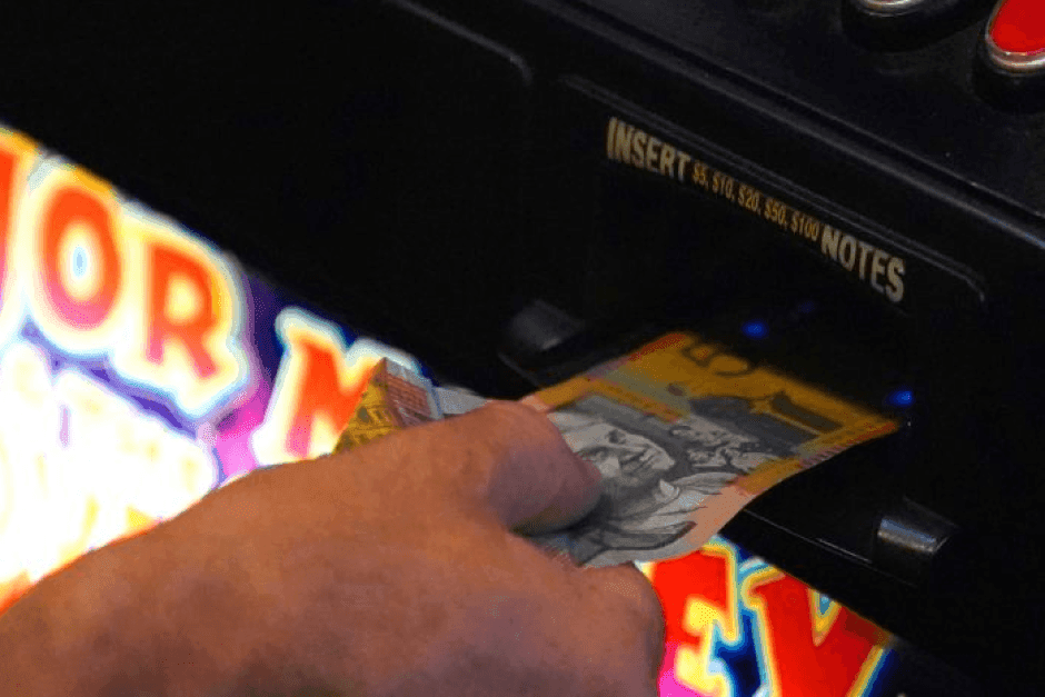Cash being fed into a slot machine.