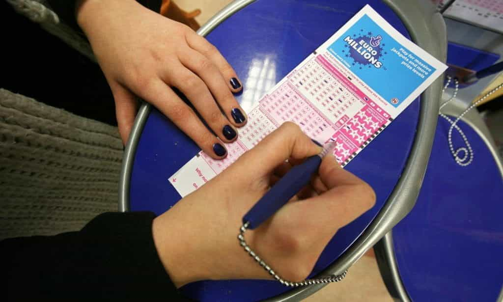 Someone filling out a EuroMillions ticket.