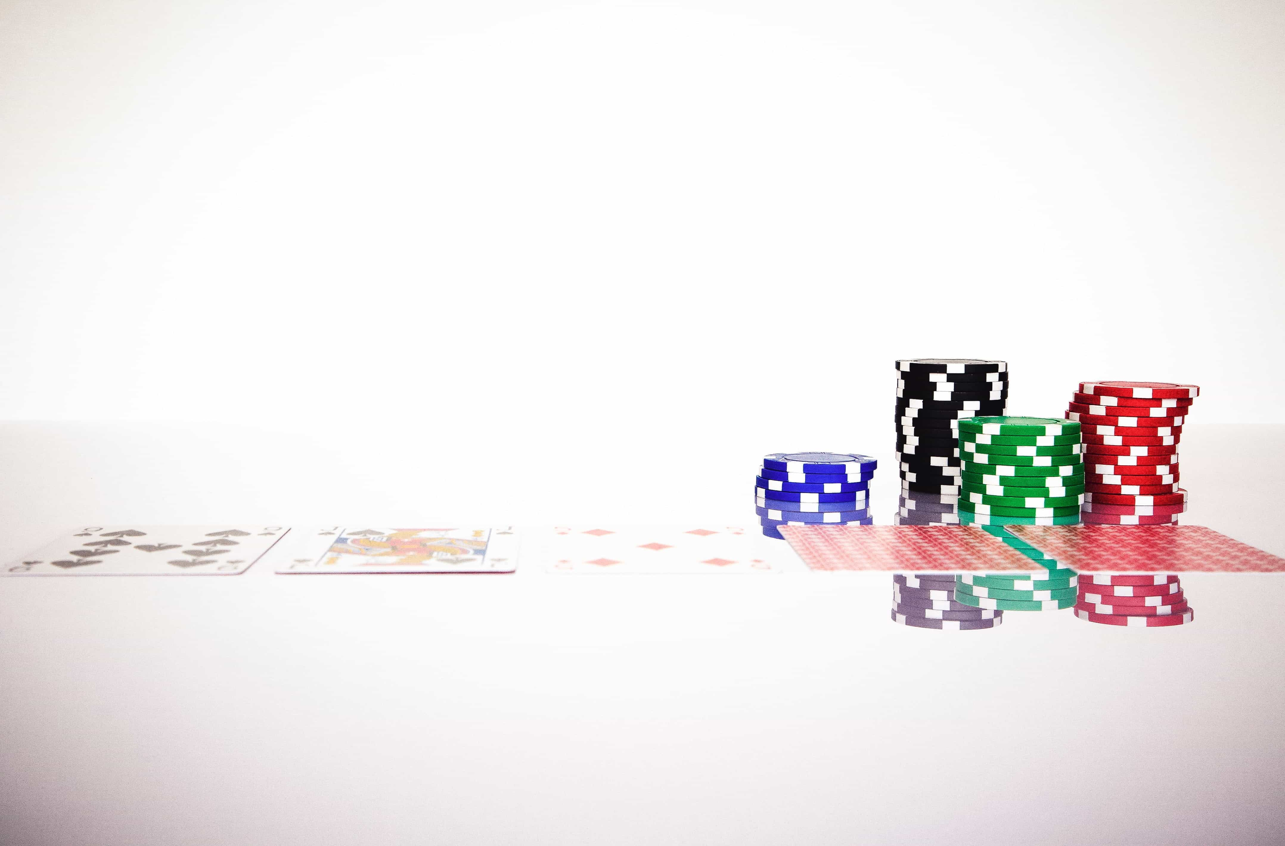 Playing cards and poker chips on a white surface.