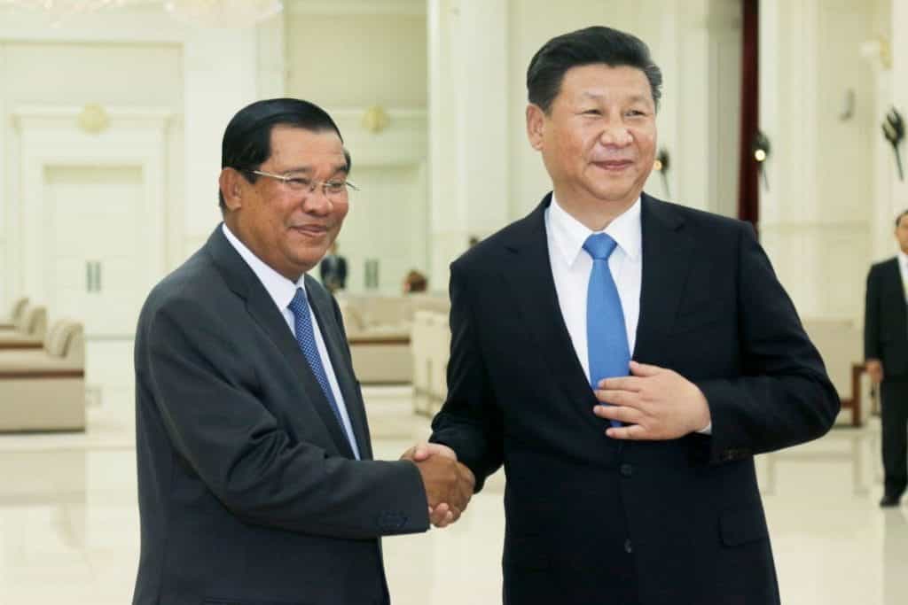 The leaders of both China and Cambodia shaking hands.