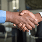Two businessmen shake hands in a deal.