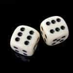 Two dice fall in front of a black backdrop.