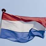 The Dutch flag flying on a flagpole.