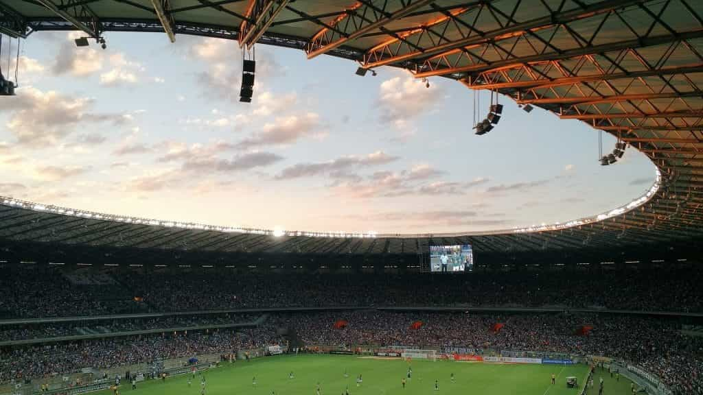 A sweeping shot of inside a football (soccer) stadium as game play continues. 