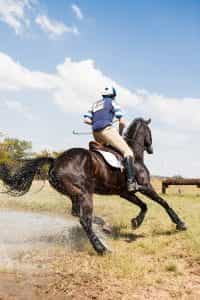 Man riding a horse outdoors in the daytime.