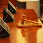 A judge’s gavel rests on a judge’s stand.