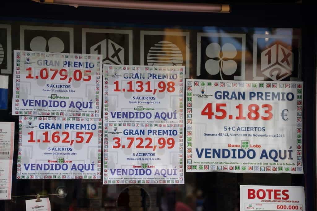 A computer graphic of many different lottery tickets in Spanish in front of a glossy black background.