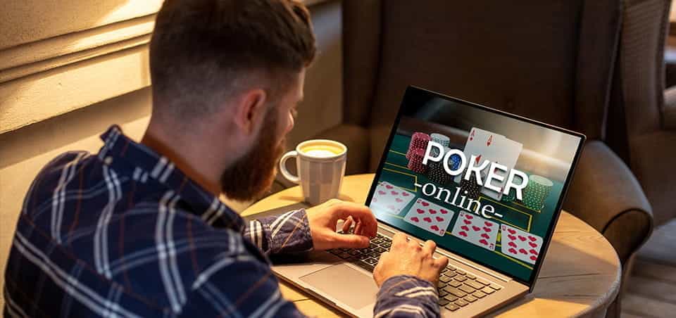 A man sitting at a laptop, browsing an online poker site.