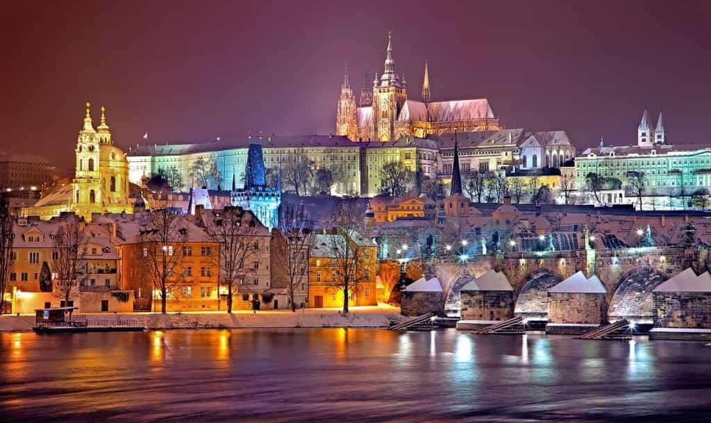 Prague with the river in the foreground at night.
