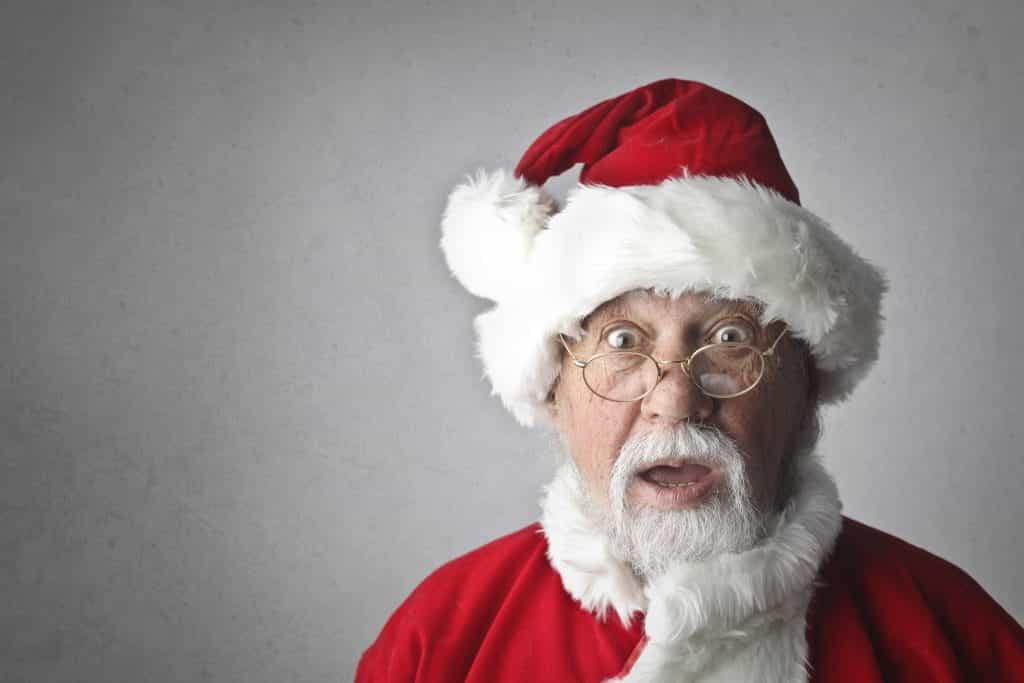 Surprised looking Santa against a grey backdrop. 