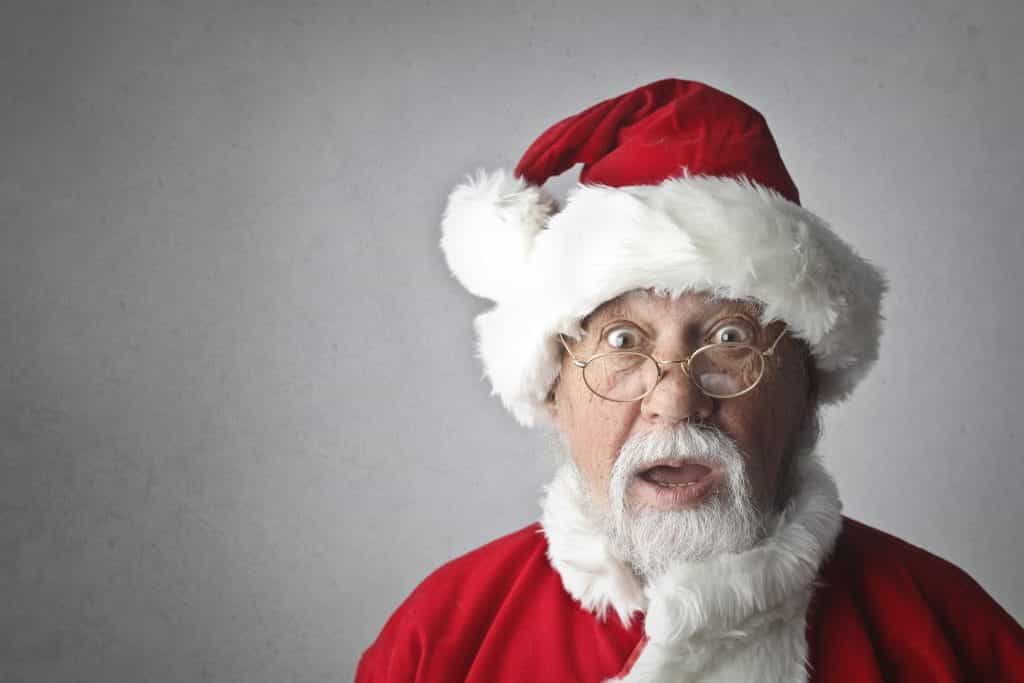 Surprised looking Santa against a grey backdrop.