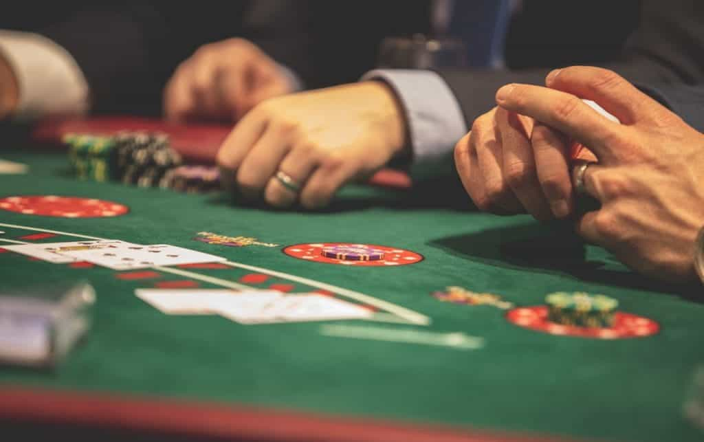 Poker players sit at a table and place bets with chips.