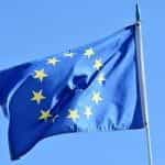The flag of the European Union flying from a flagpole.