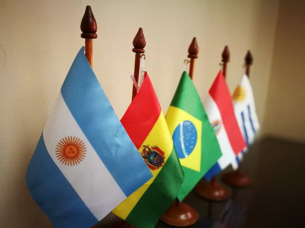 A color image of a row of small flags for a number of Latin American countries: Argentina, Brazil, and Uruguay among them.