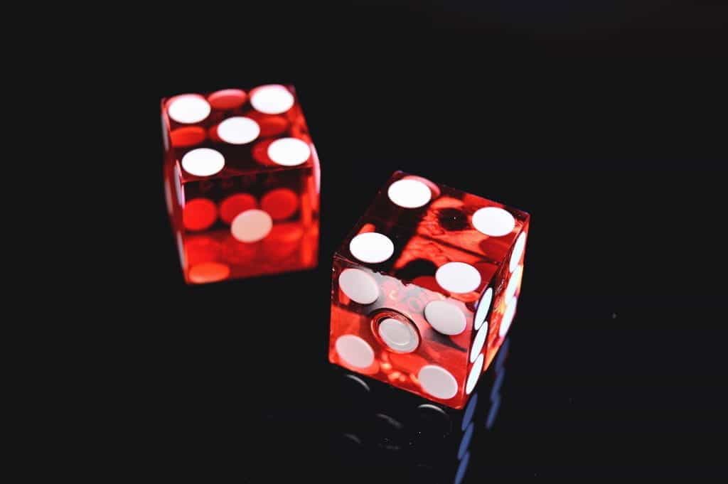 Two red dice on a black background.