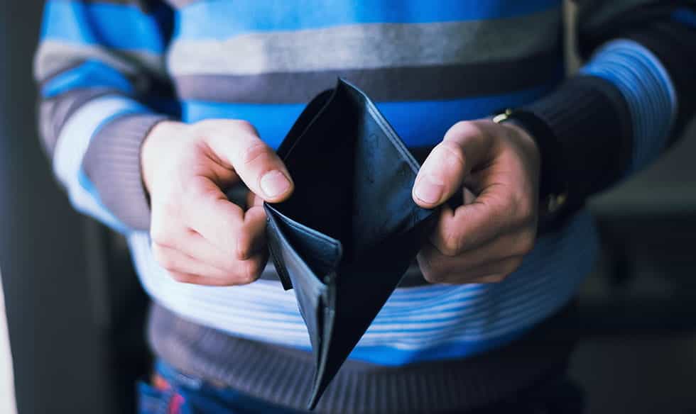 A person looking through an empty wallet.