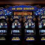 Three slot machines line an arcade wall.