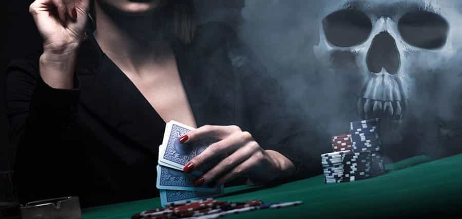 A woman holding playing cards, sitting at a gambling table, with a skull in the background.