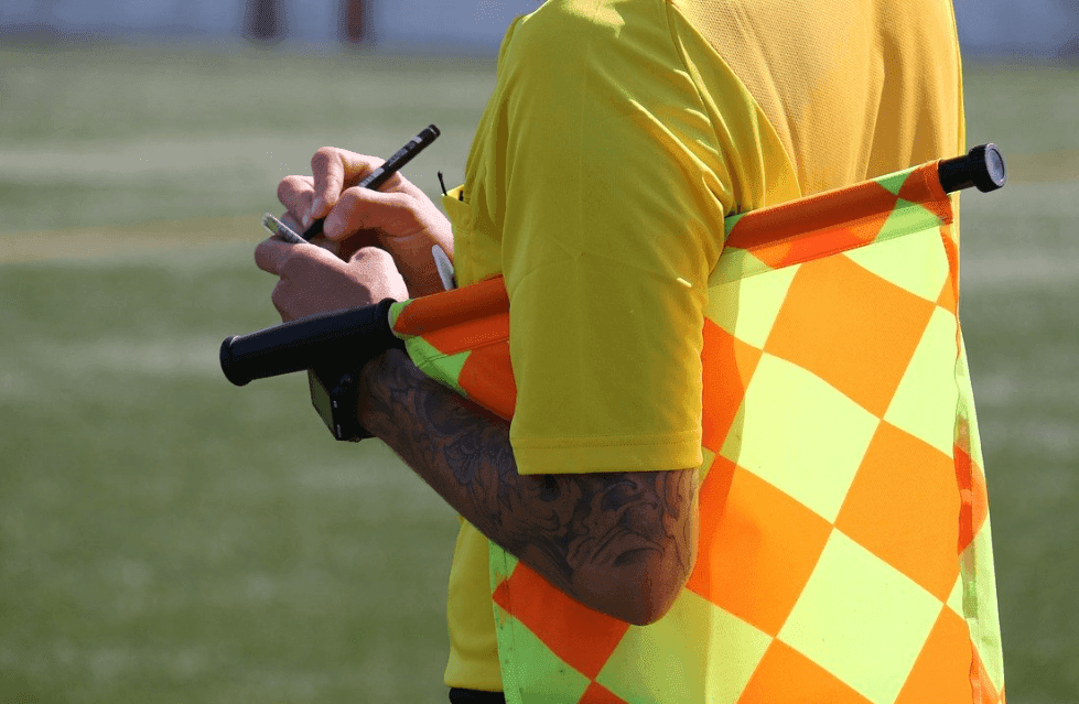 A football official taking note of a booking.