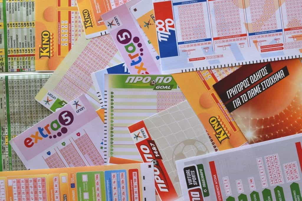 A number of different kinds of lottery tickets laid out on top of each other.