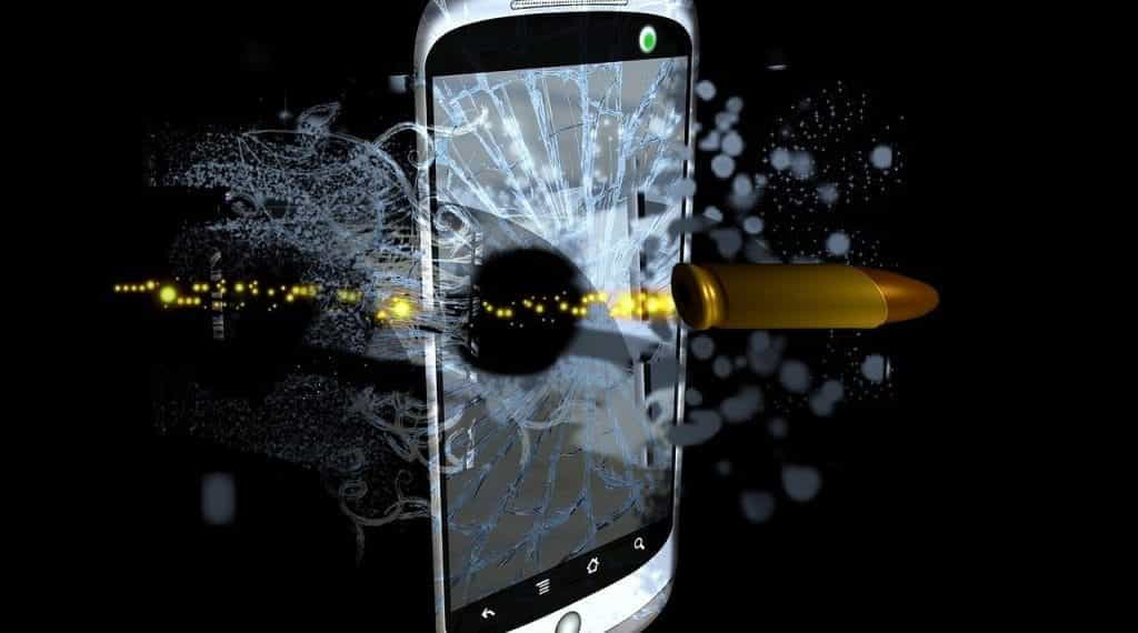 A bullet smashing the screen of a mobile phone.