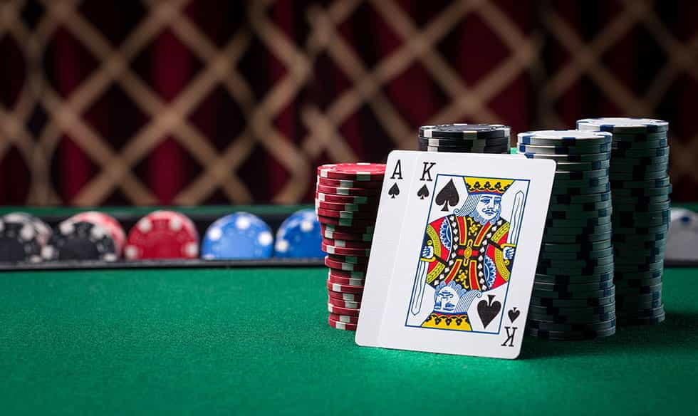 An Ace and King of Spades resting against a stack of poker chips.