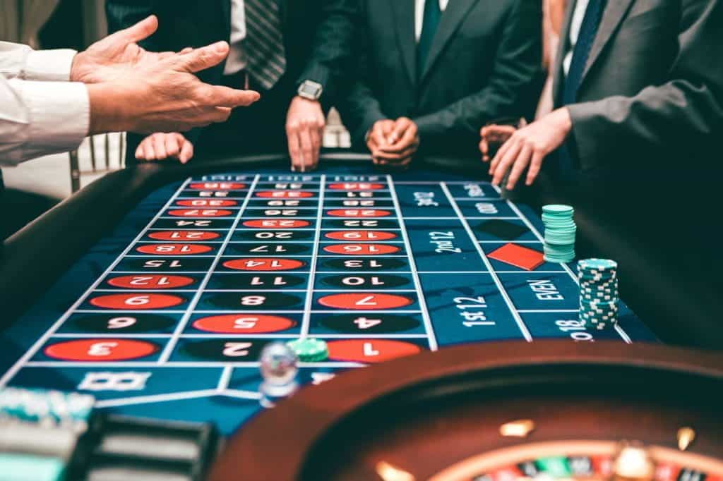 Men in suits play poker at a casino.