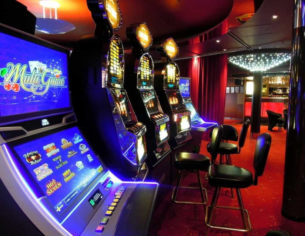 A number of video slot machines in a casino floor, with one offering multi games.