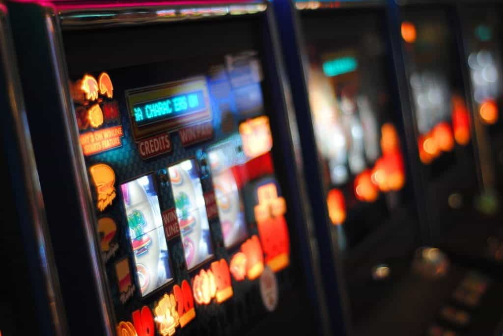 Bright colorful lights on a row of slot machines.