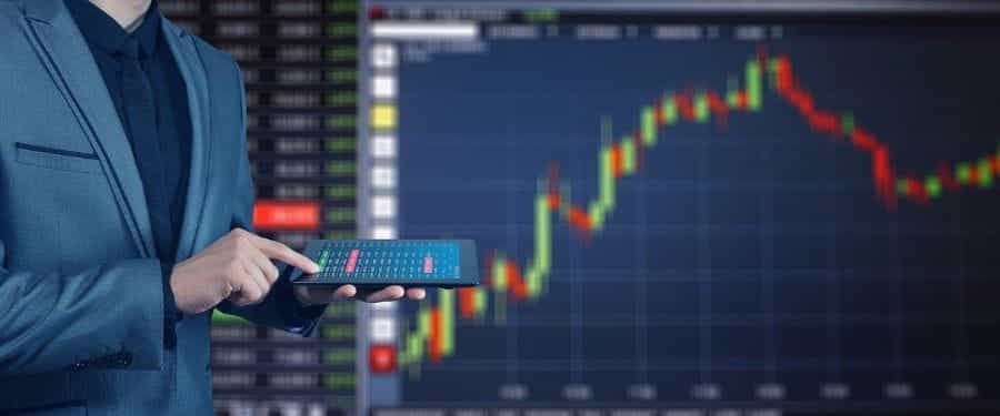 A person stood in front of a graph of stock value.
