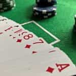 Cards and chips laid down on a green felt casino table.