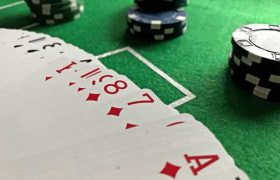 Cards and chips laid down on a green felt casino table.