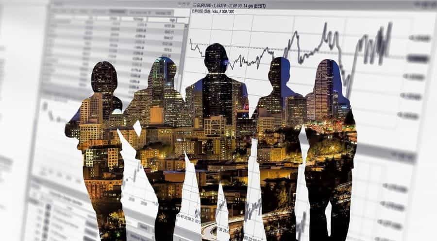 Business people silhouetted against stock market data.